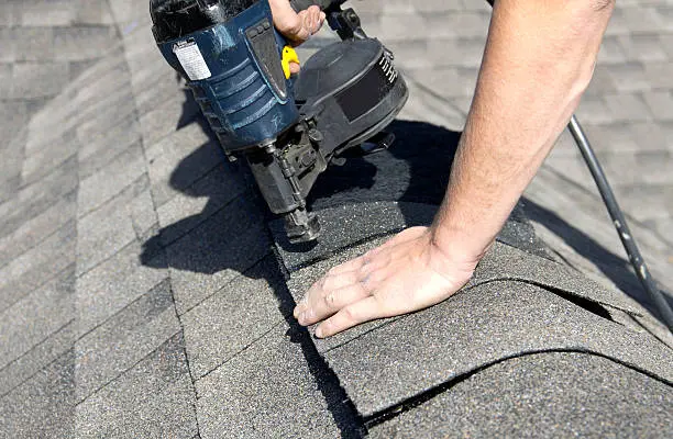 Insurance Claim 2 Roofer nailing asphalt shingles with a nail gun