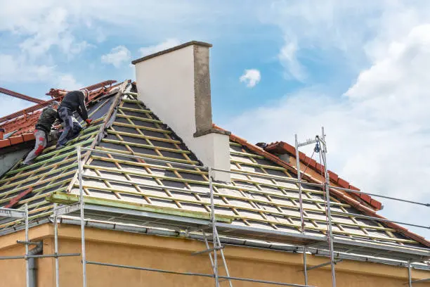 Home 12 Worker on a roof during shingle replacement