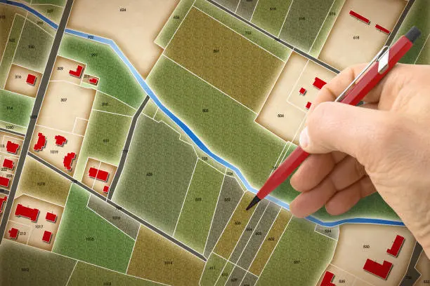 A Step-by-Step Guide: How to Choose the Perfect Lot for Your New Home 3 Hand marking property parcels on a land map