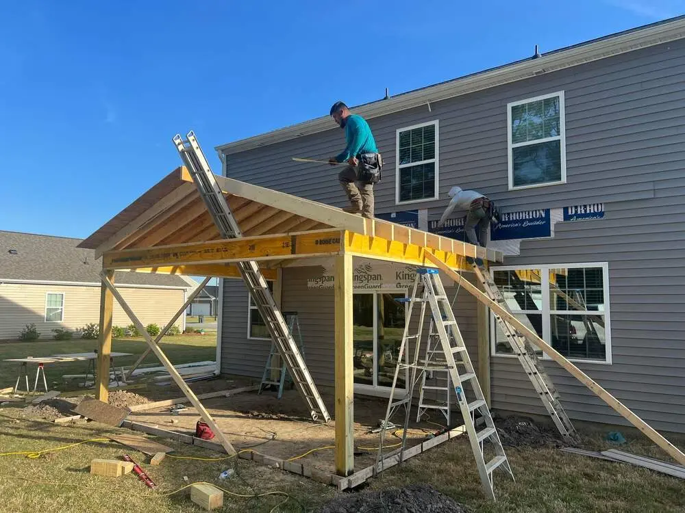 Home Additions Greenville NC 2 Crew framing a new porch roof on a home addition