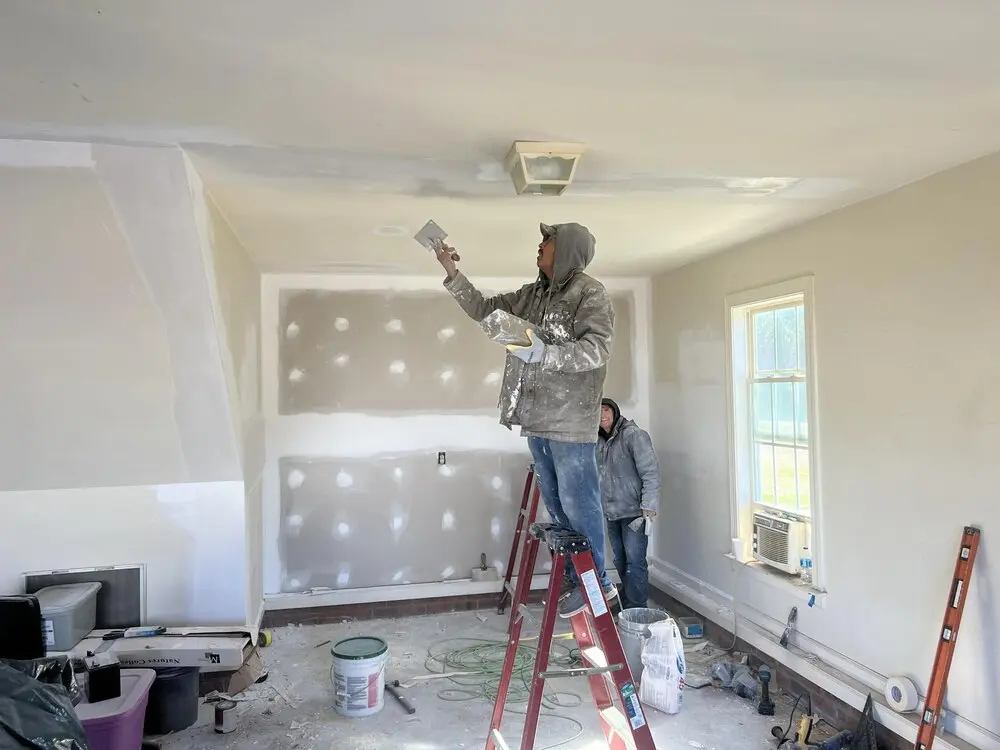 About Us 7 Contractor working on drywall inside a home addition