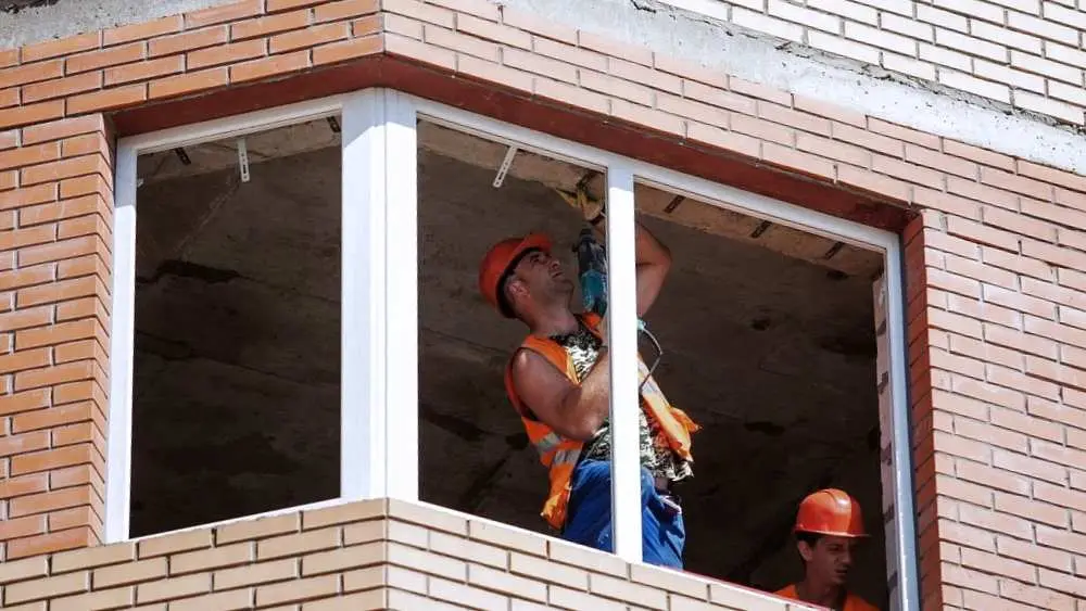 Window Installation & Replacement Greenville NC 4 Worker installing a window in a brick home in Greenville, NC
