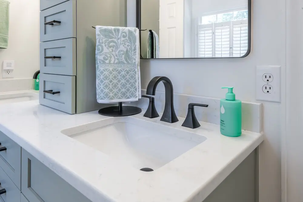 Bathroom Remodel In Greenville NC 1 Bathroom vanity with white countertop, black faucet and mirror